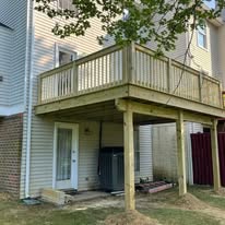 Pressure-treated deck build with stairs on back of house