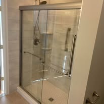 Bathroom shower with glass sliding door and white subway tile