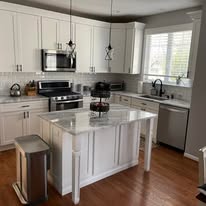 Kitchen remodel with white cabinets, island, and hardwood floors