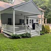 Covered porch addition with white columns and railings