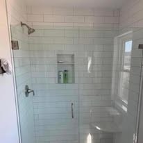 Walk-in shower with white subway tile and frameless glass door
