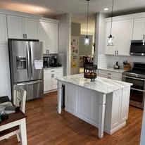 Kitchen remodel with white cabinets, island, and hardwood floors