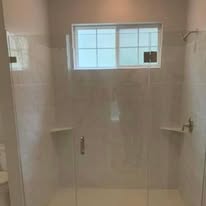 Frameless glass shower with white tile walls