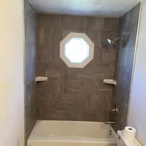 Bathroom tub and shower combo with tile and octagon window