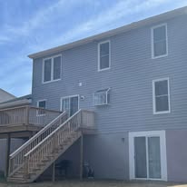 House exterior with new siding and elevated deck with stairs