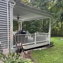 Covered porch with ceiling fan and white railings