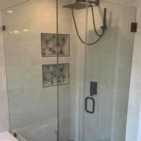 Glass shower with white subway tile and decorative accent tiles